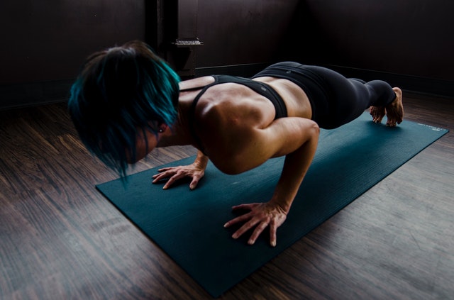 Woman doing push ups on gym mat
